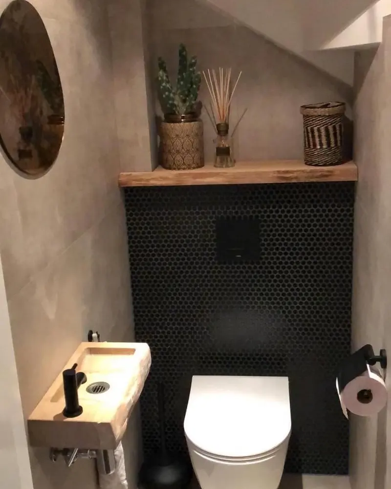 Lavabo com parede de pastilhas pretas, prateleira de madeira e cuba suspensa
