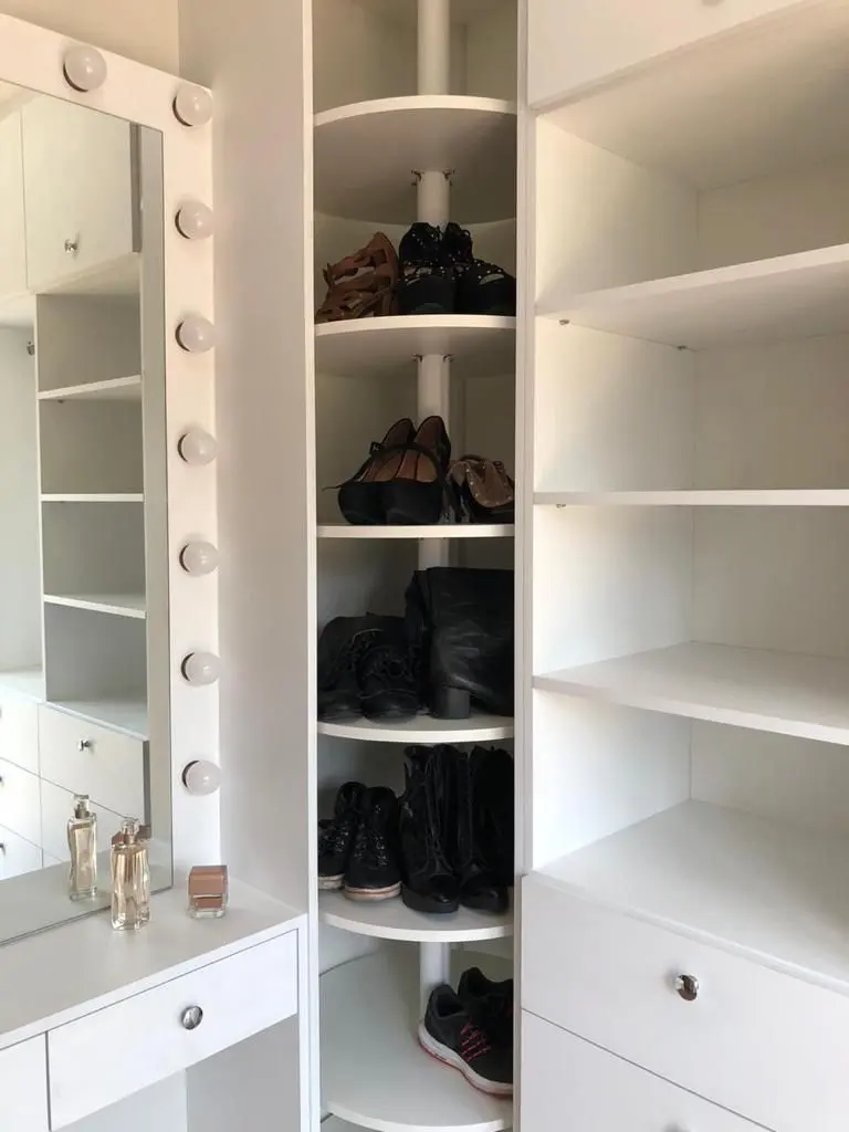 Closet com sapateira giratória, prateleiras e espelho com lâmpadas