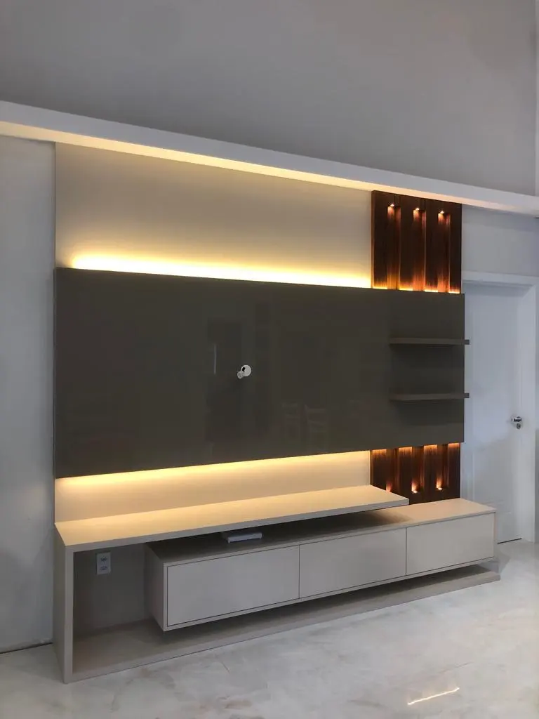 Painel de TV grafite com nichos iluminados e rack branco