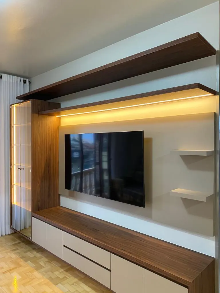 Painel de TV com prateleira de madeira iluminada e rack suspenso